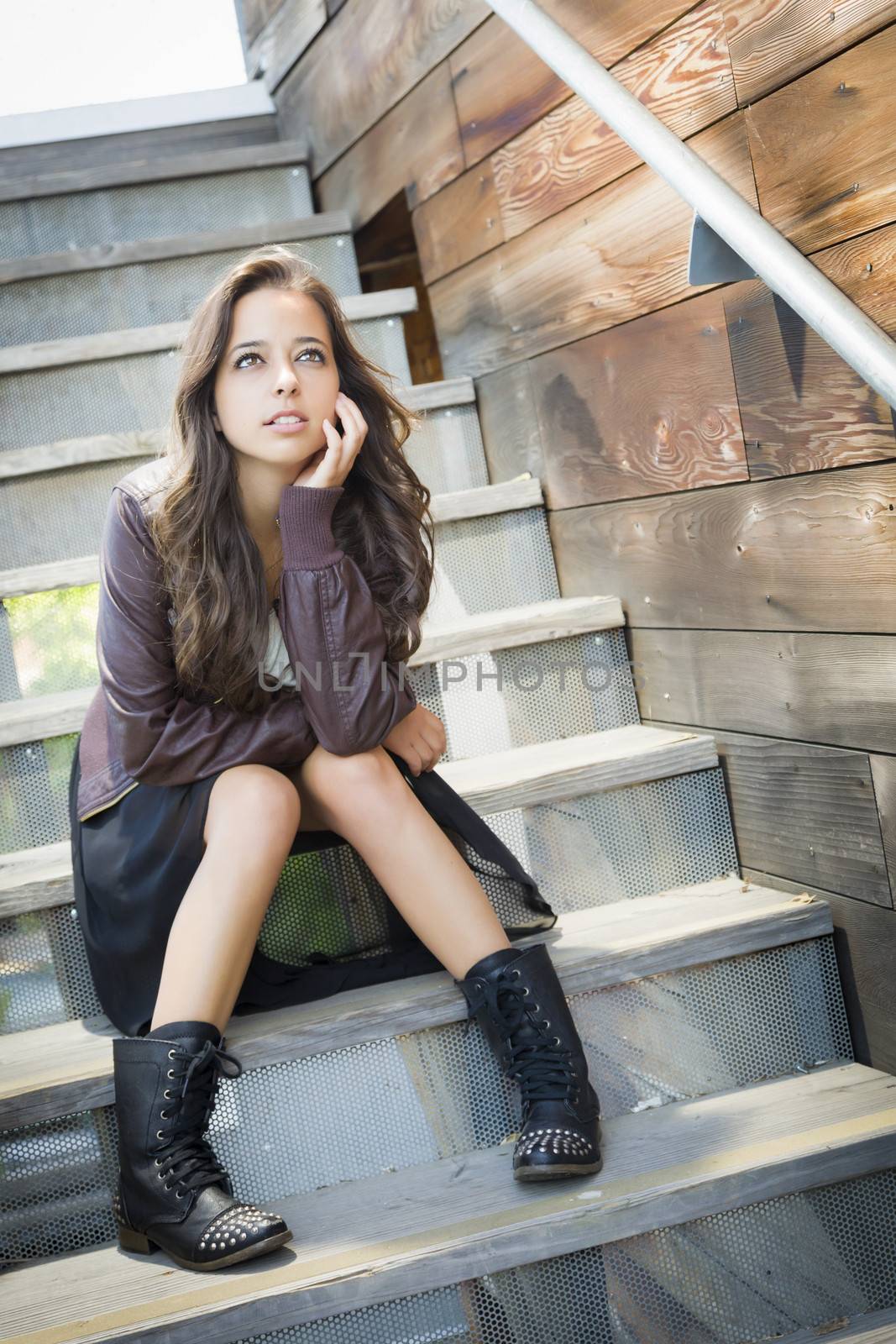 Portrait of a Pretty Mixed Race Young Adult Woman Sitting on a Staircase Wearing Leather Boots and Jacket.