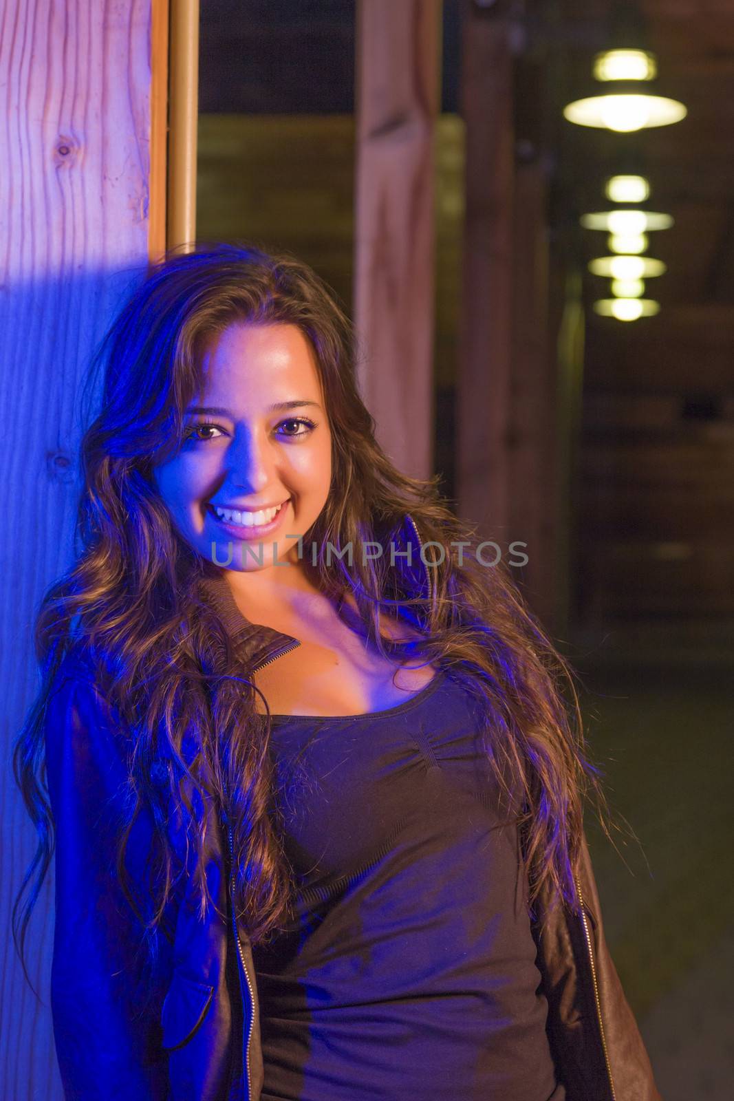 Night Portrait of Pretty Mixed Race Young Adult Woman Leaning Against a Wood Post.