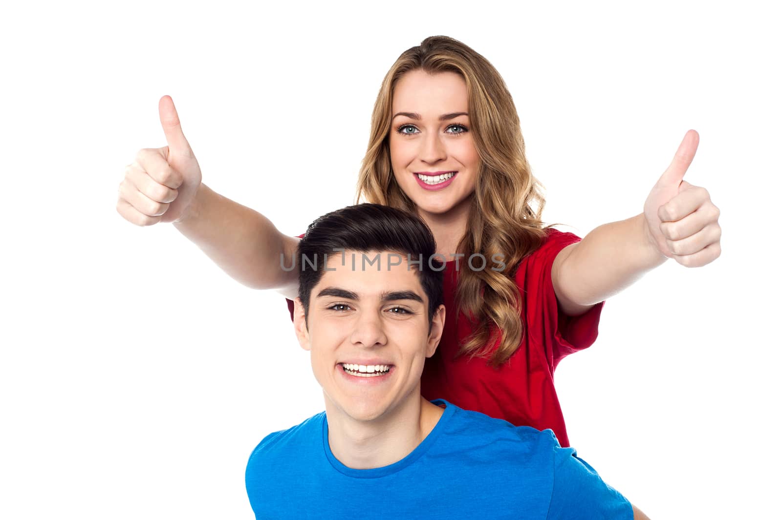 Joyous woman enjoying piggy ride and showing double thumbs up by stockyimages