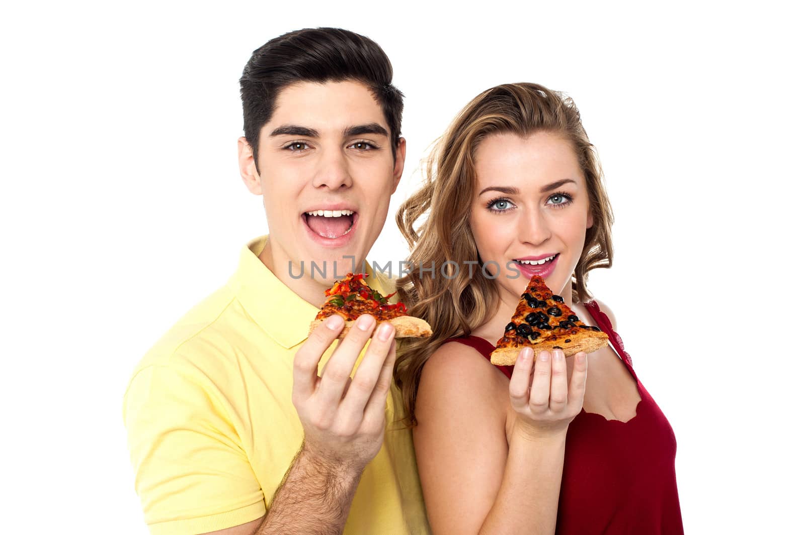 Couple posing with pizza slice, about to eat by stockyimages