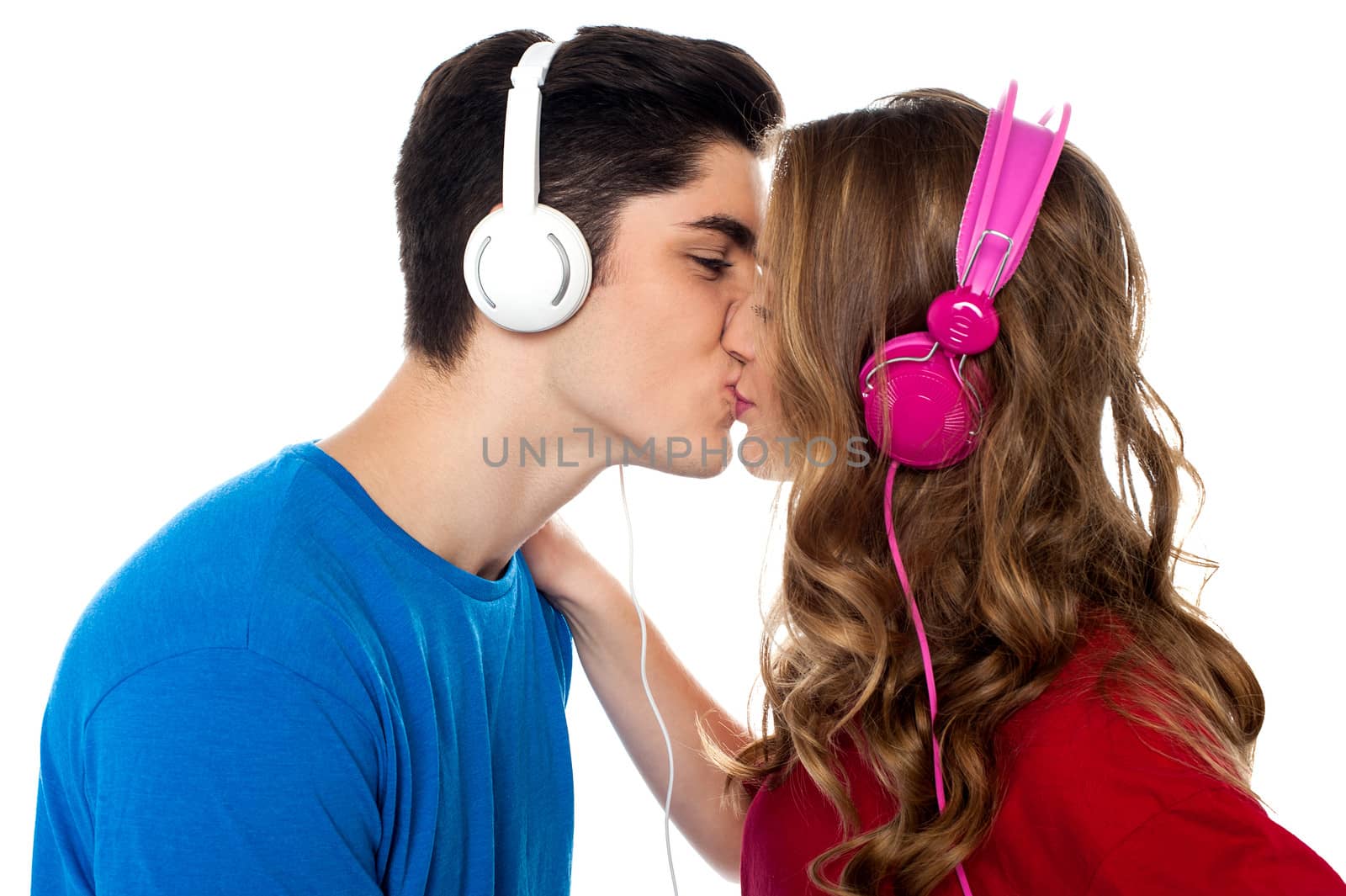 Love couple tuned into musical world and kissing each other