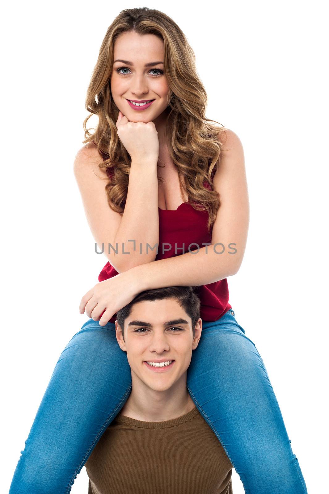Pretty girl sitting on the shoulders of her boyfriend by stockyimages