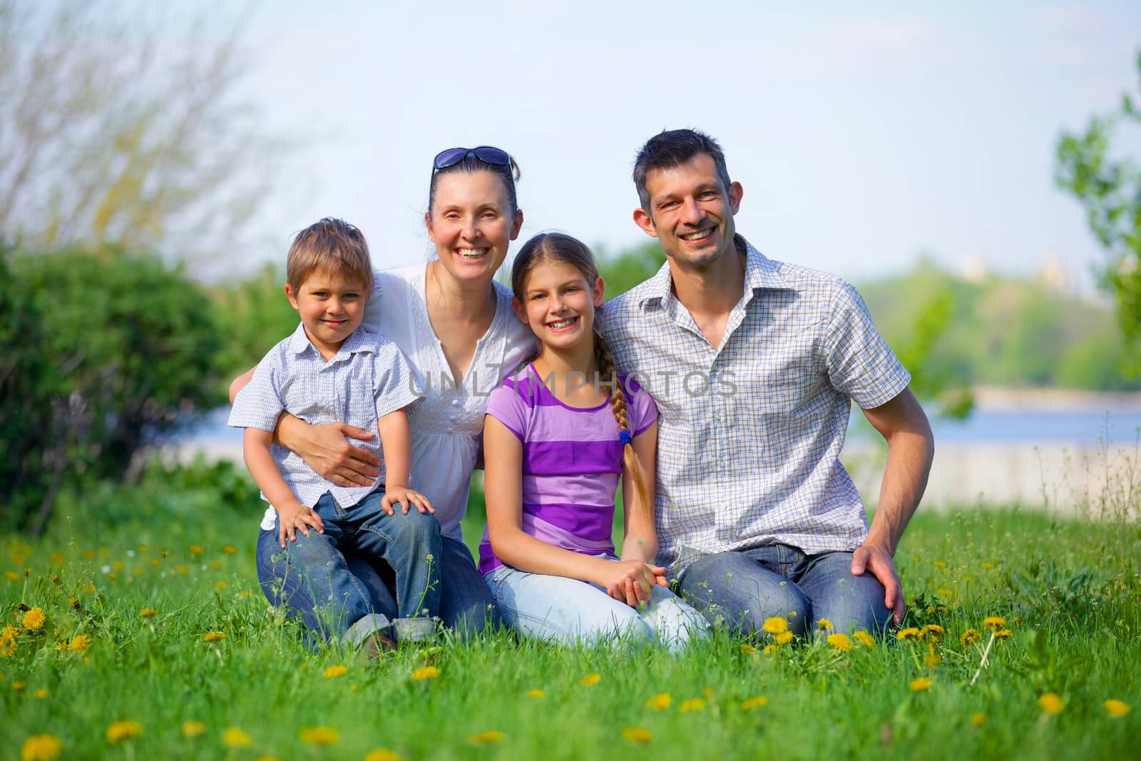 happy young couple with their children have fun at beautiful park outdoor in nature