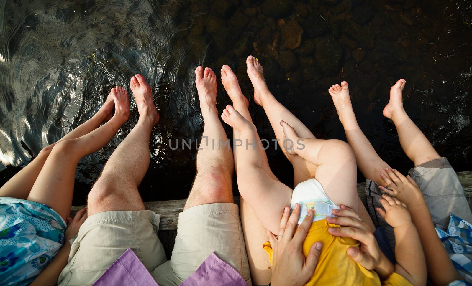 Family dipping their tows in water on a warm summer day