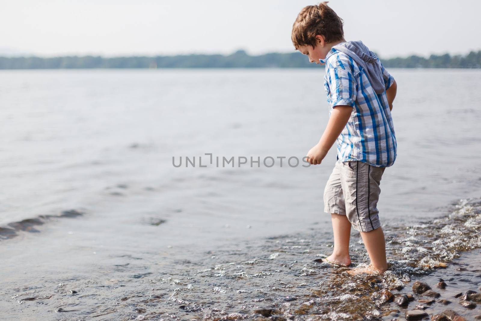 Boy walking in water by Talanis