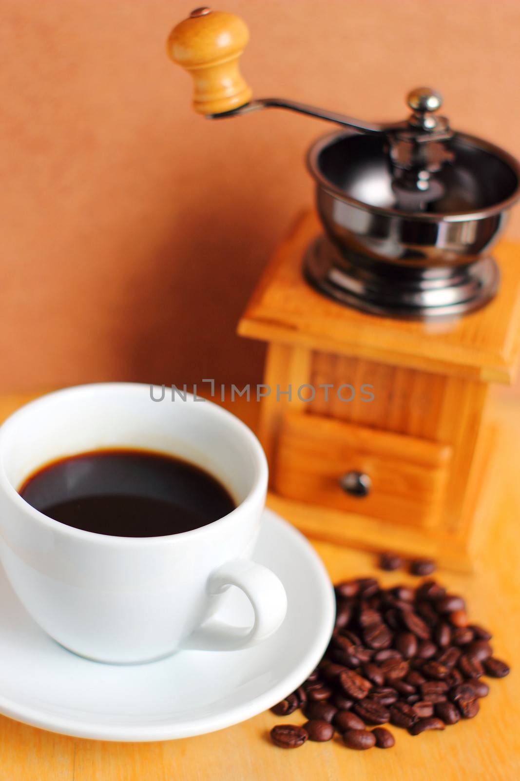Cup of hot coffee with coffee grinder and beans  by nuchylee
