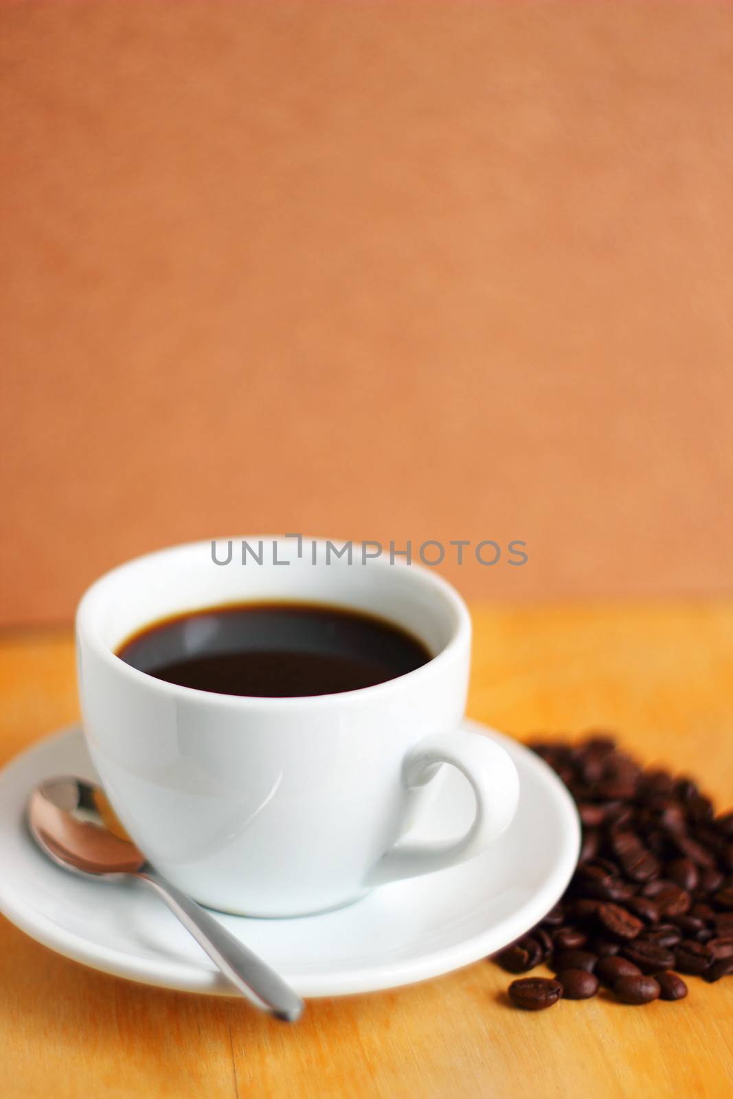 White cup of coffee with coffee beans and spoon by nuchylee