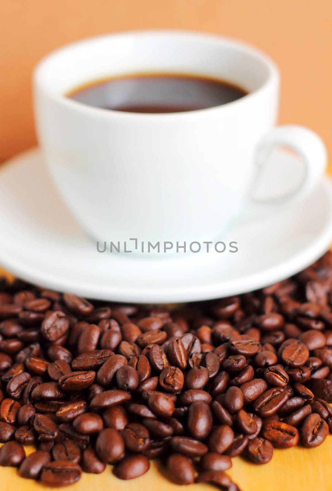 White cup of coffee on coffee beans