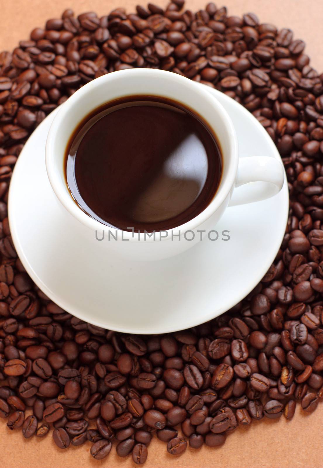 Cup of coffee on coffee beans