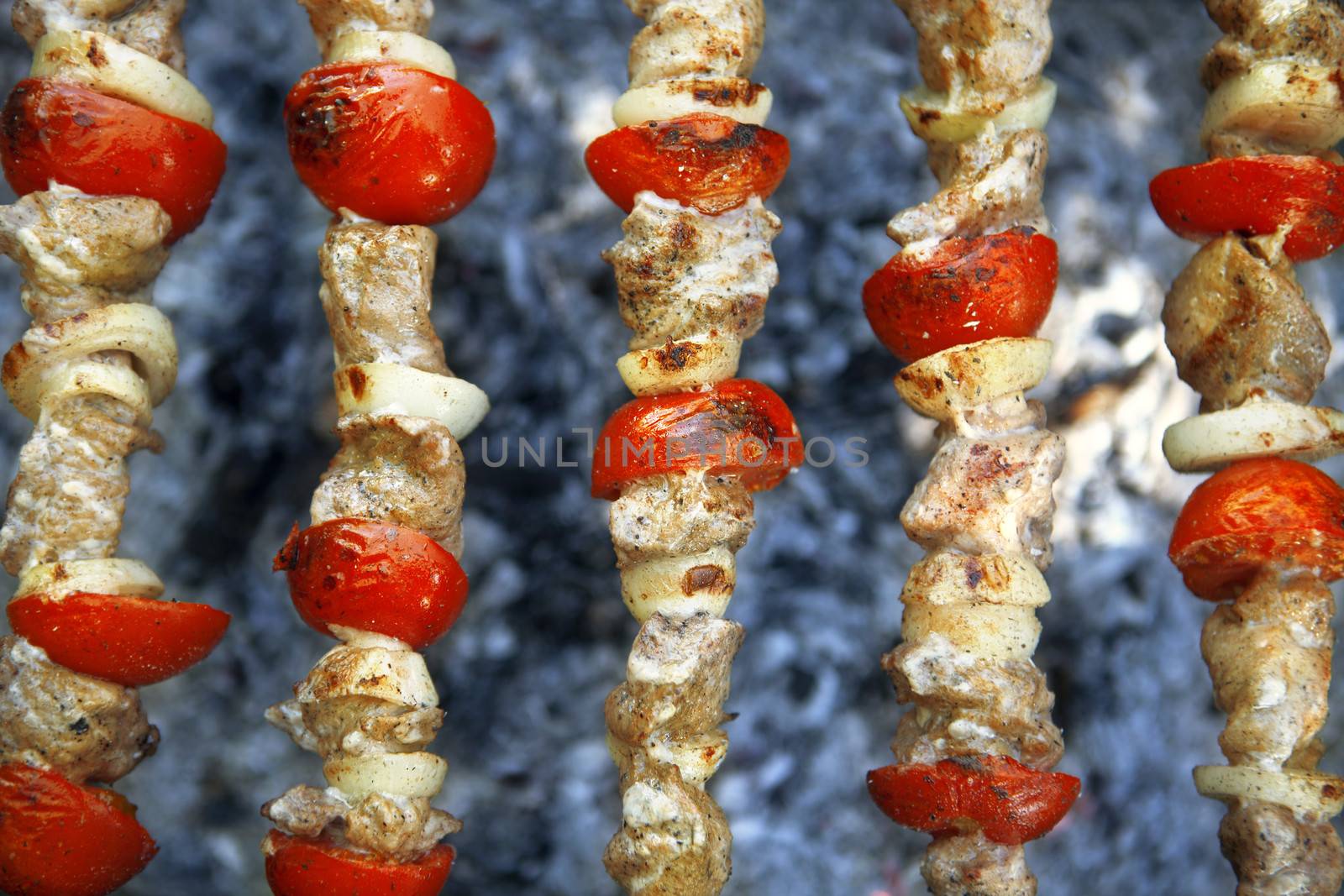 meat preparation with tomatoes on a grill