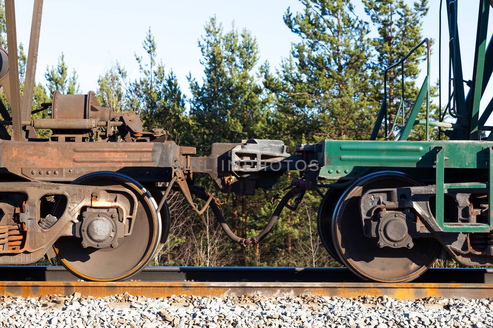 Freight wagon train. automatic coupling. In a forest and blue sky.