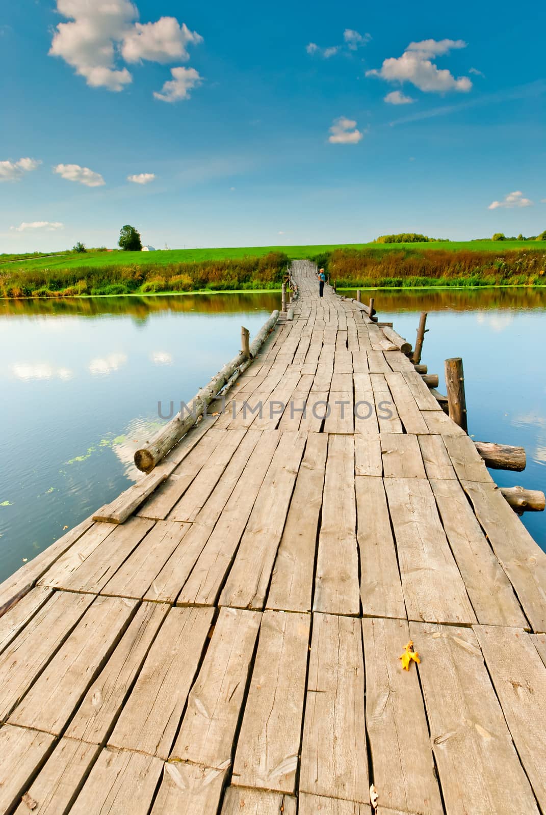 wooden bridge over a small lake in the early morning