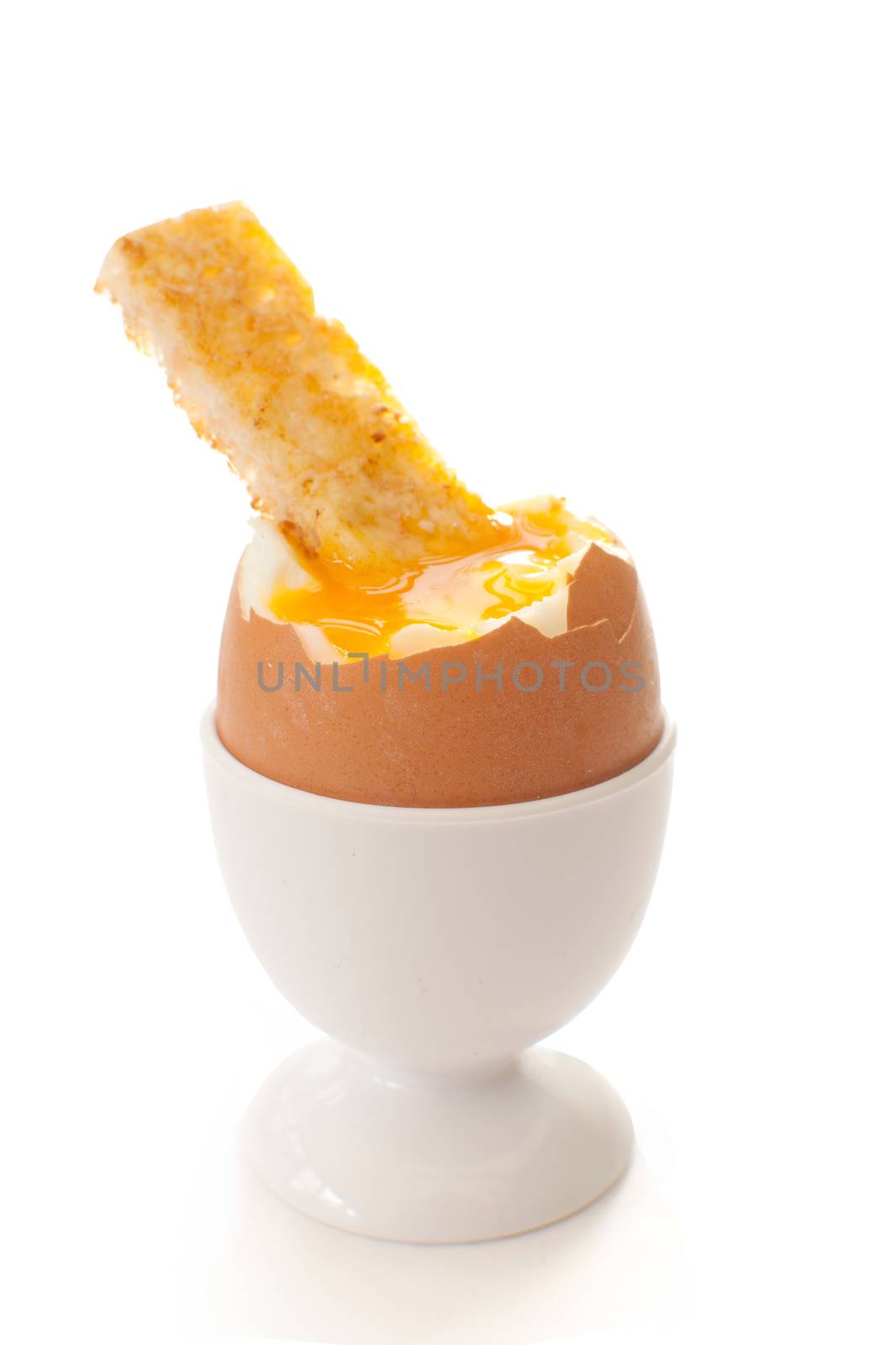 Boiled egg in a cup holder with a buttered toasted soldier