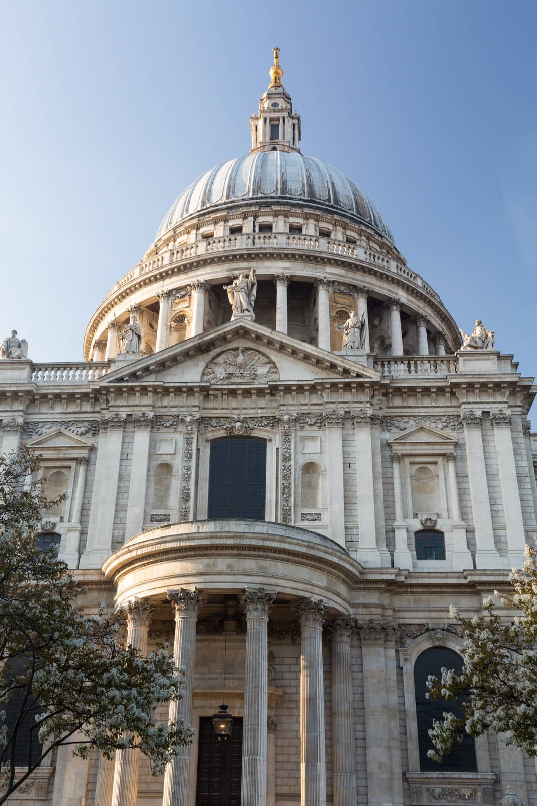 West front of St Pauls Cathedral in London England at dusk as the sun is setting low in sky.