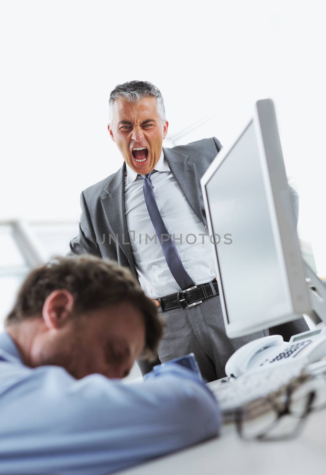 Tired business man sleeping at work. In the background is angry boss shouting