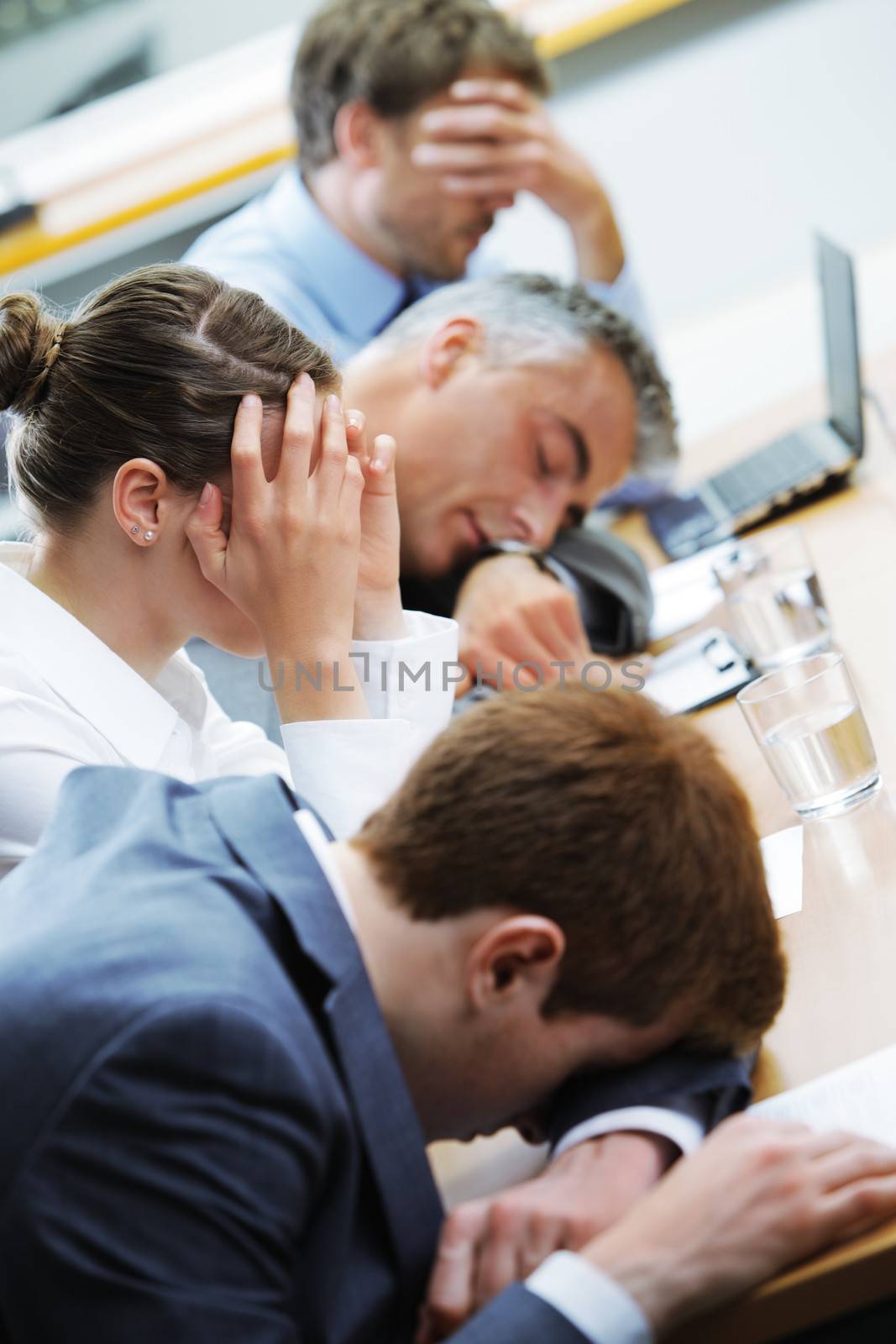 Business people sleeping in the conference room during a meeting, focus on woman
