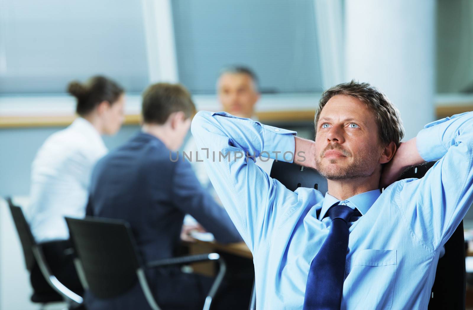 Portrait of a relaxed Businessman with meeting in the background