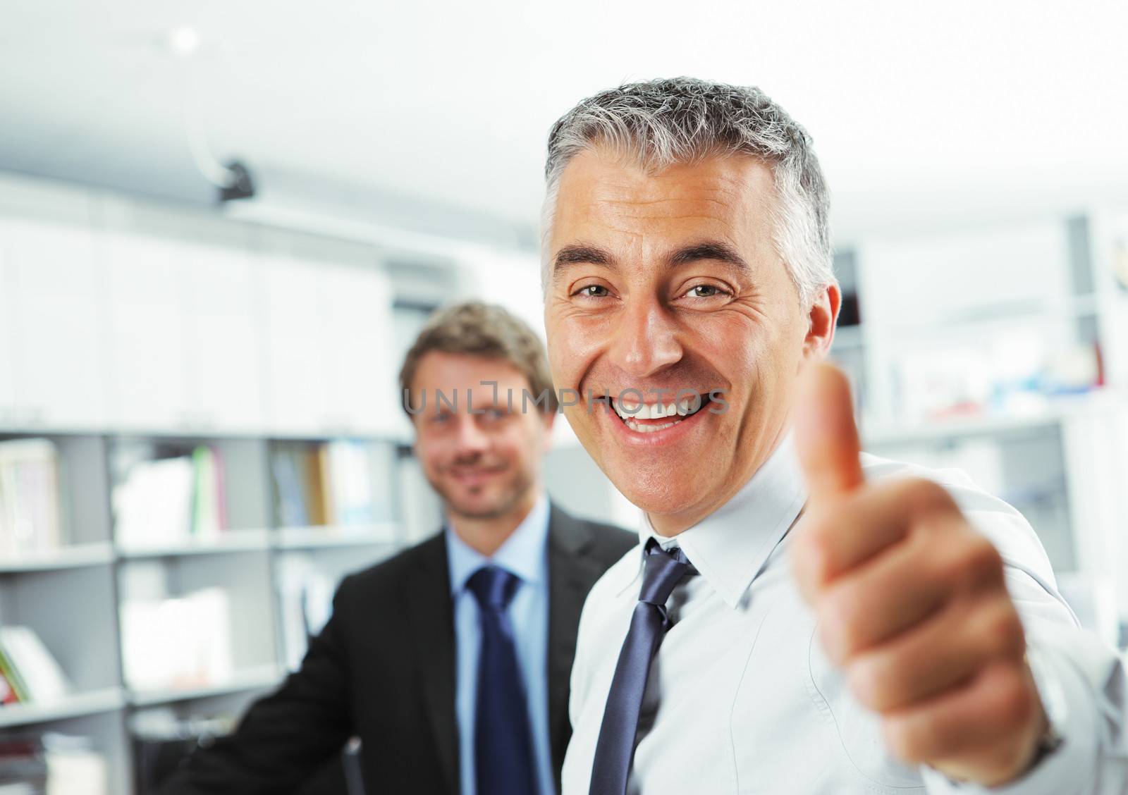 Happy businessman showing thumbs up sign