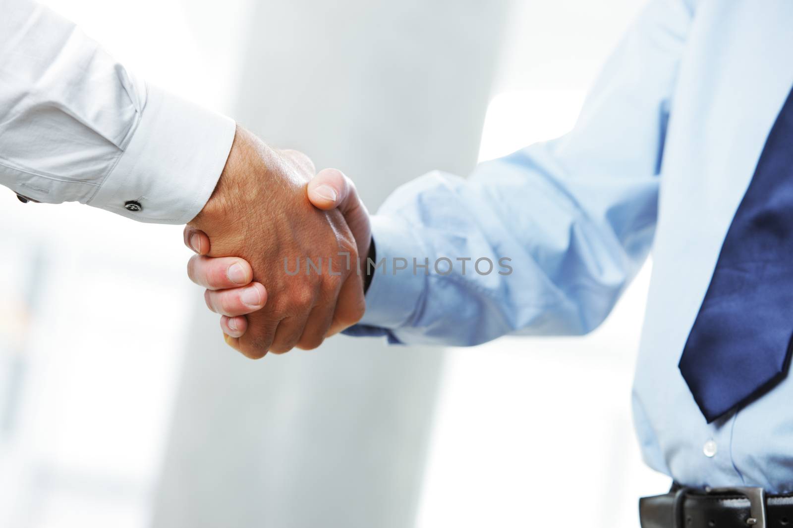 Businessmen shaking hands by stokkete