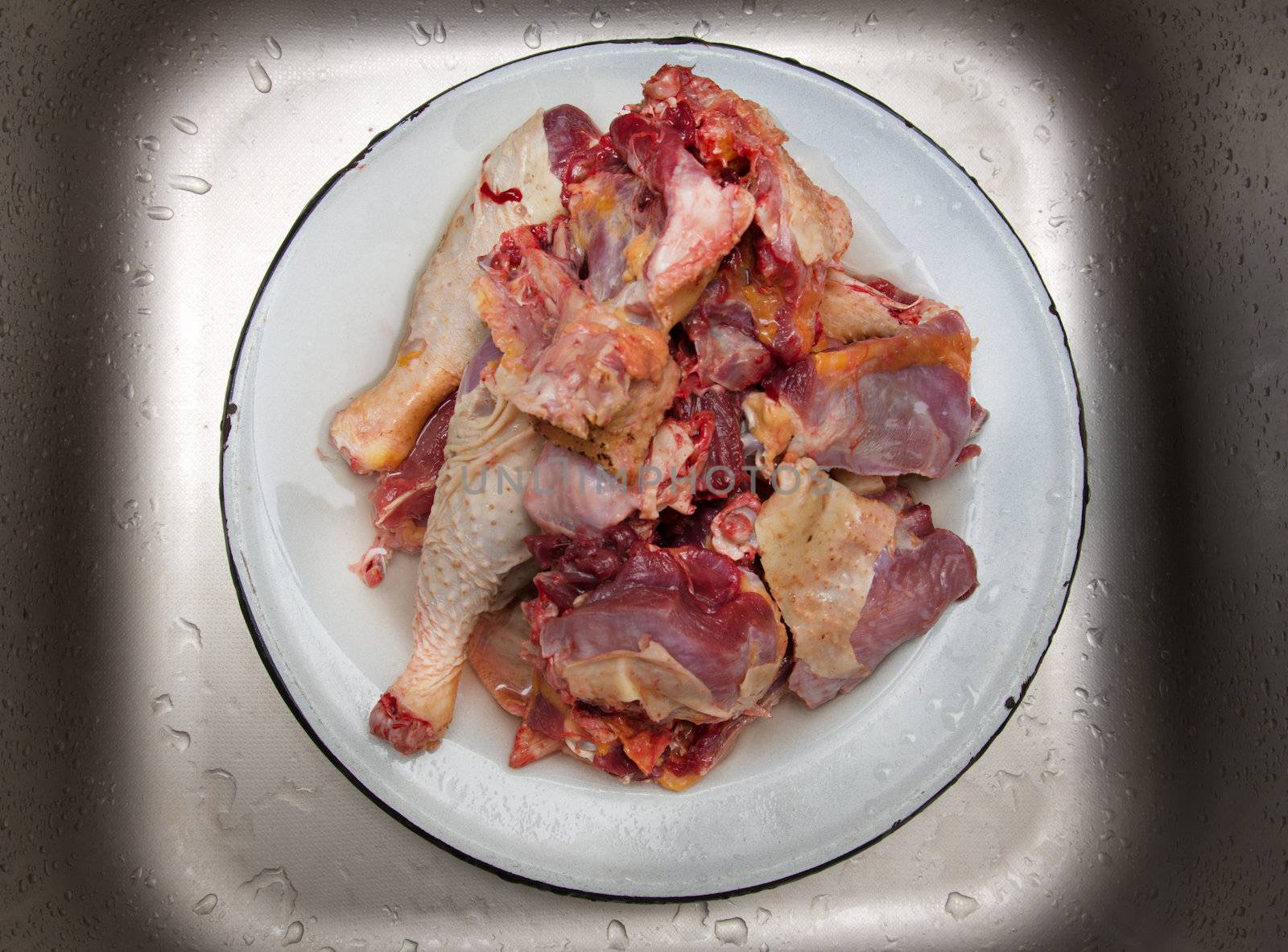 meat in a dish on a metal background with water drops