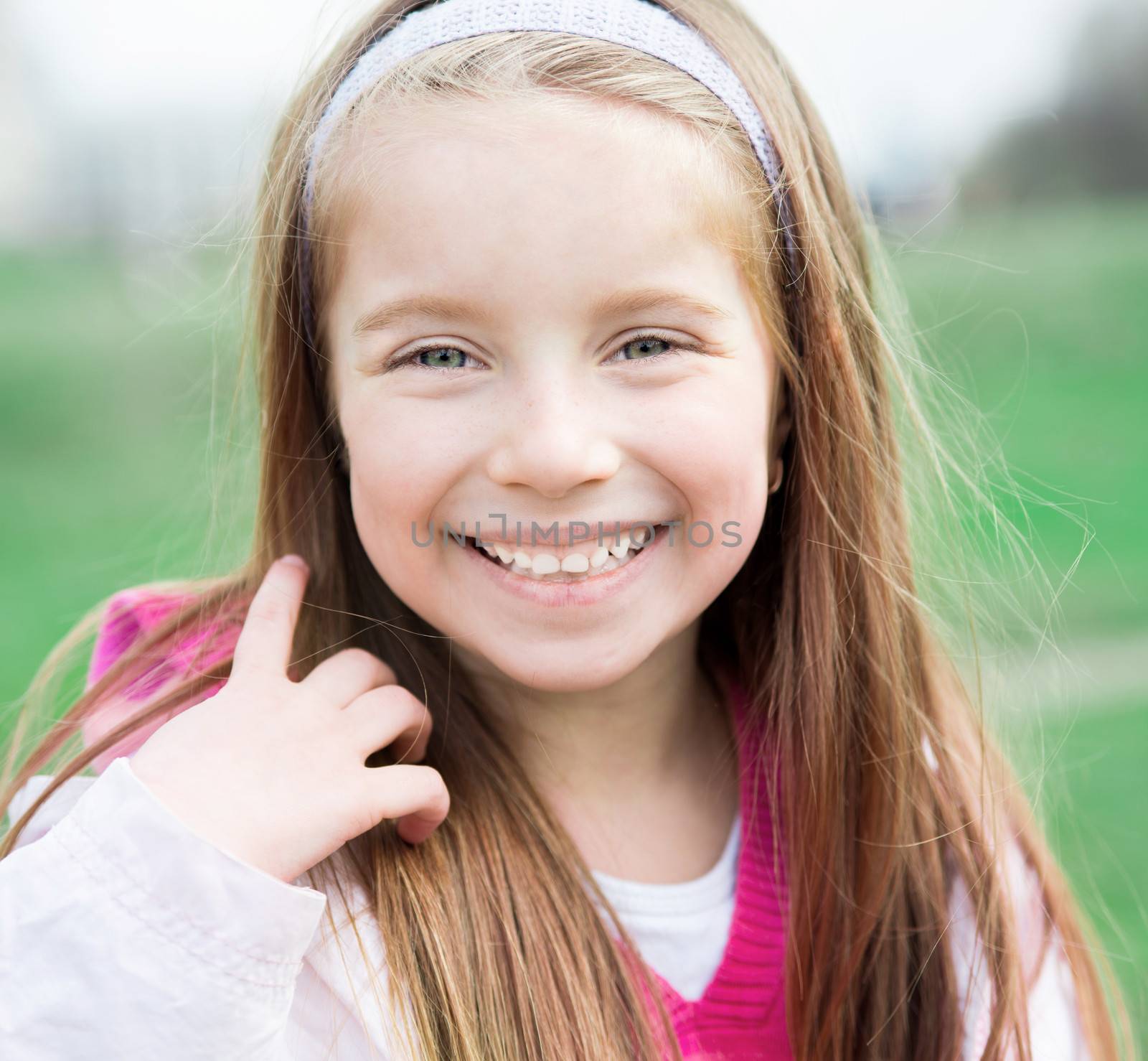 Close-up portrait of a pretty smiling liitle girl