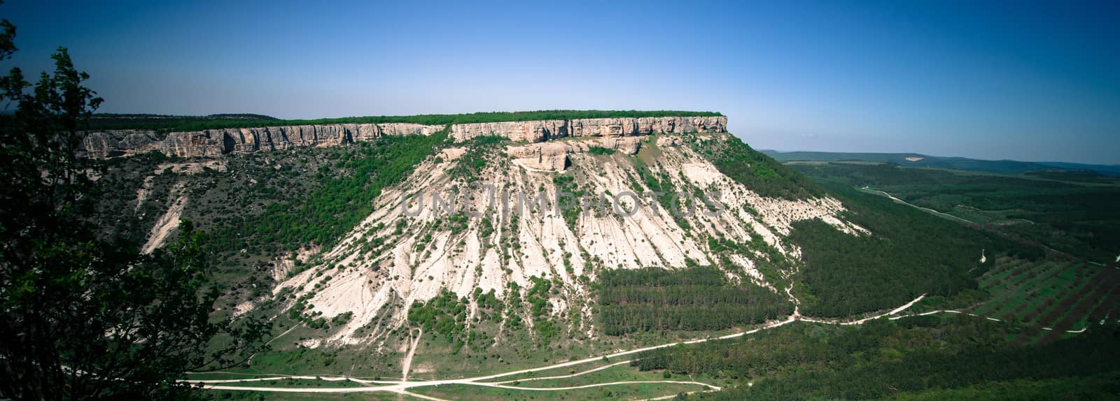 green hill with a road around