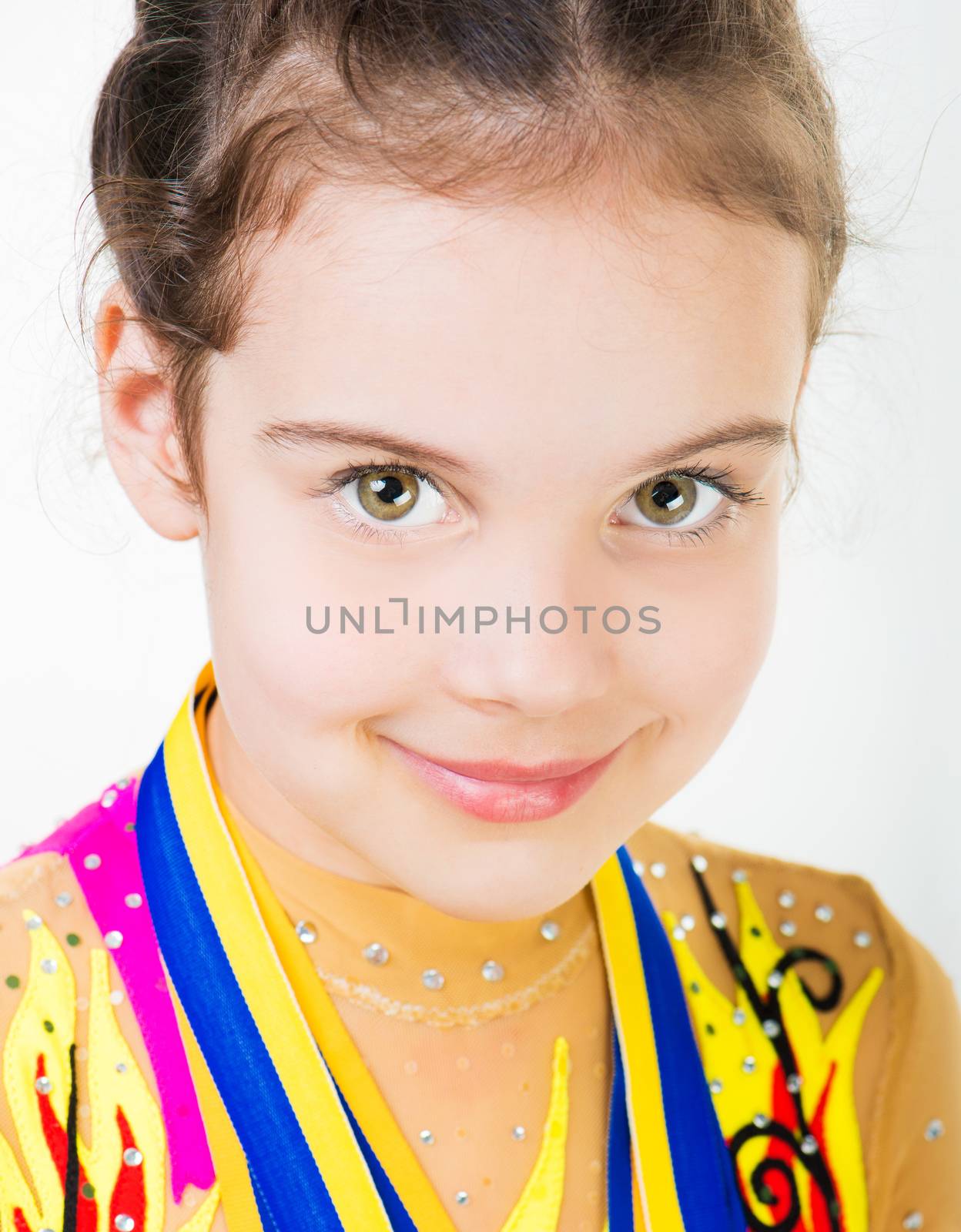 little girl gymnast with a medal isolated on a white background