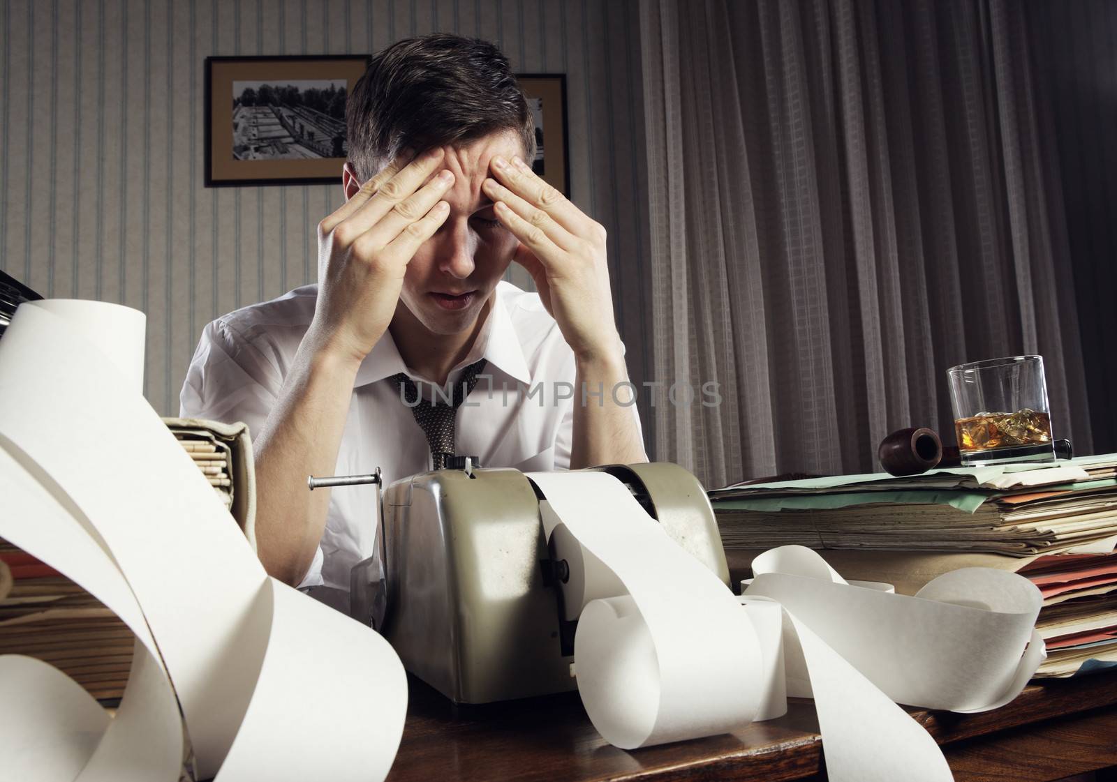 Tired businessman is sitting at a table full of paperwork