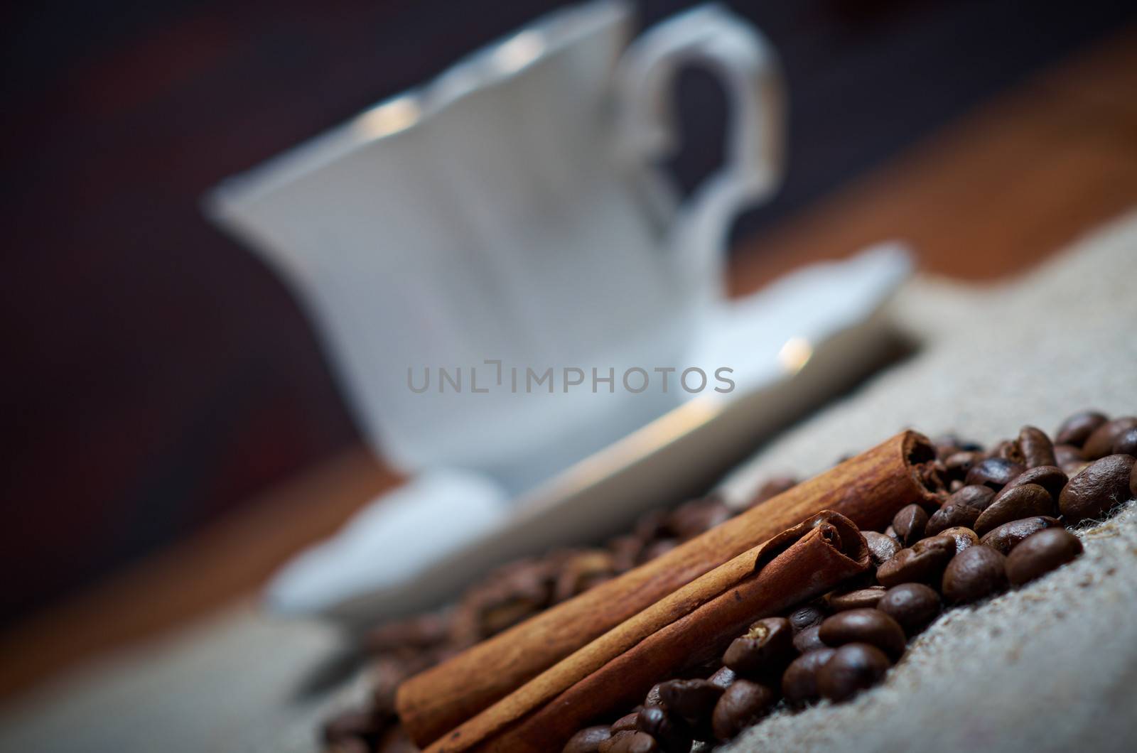 Coffee cup with cinnamon and coffee beans background