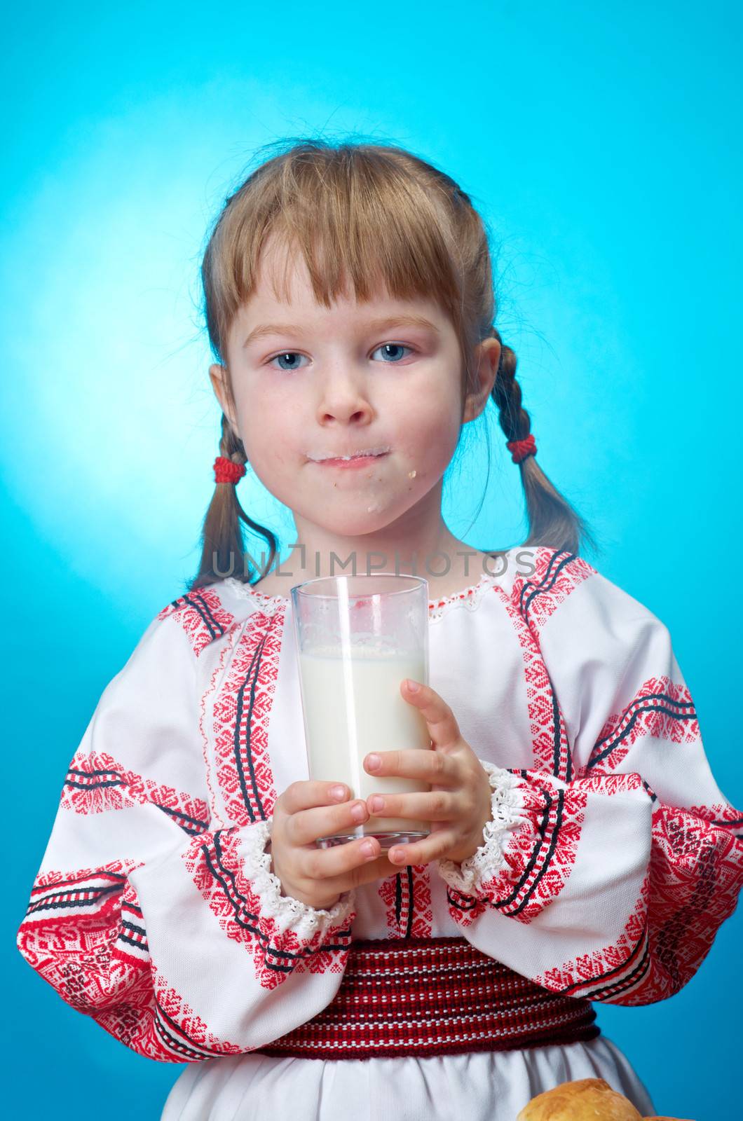 Russian little girl drinking glass of milk