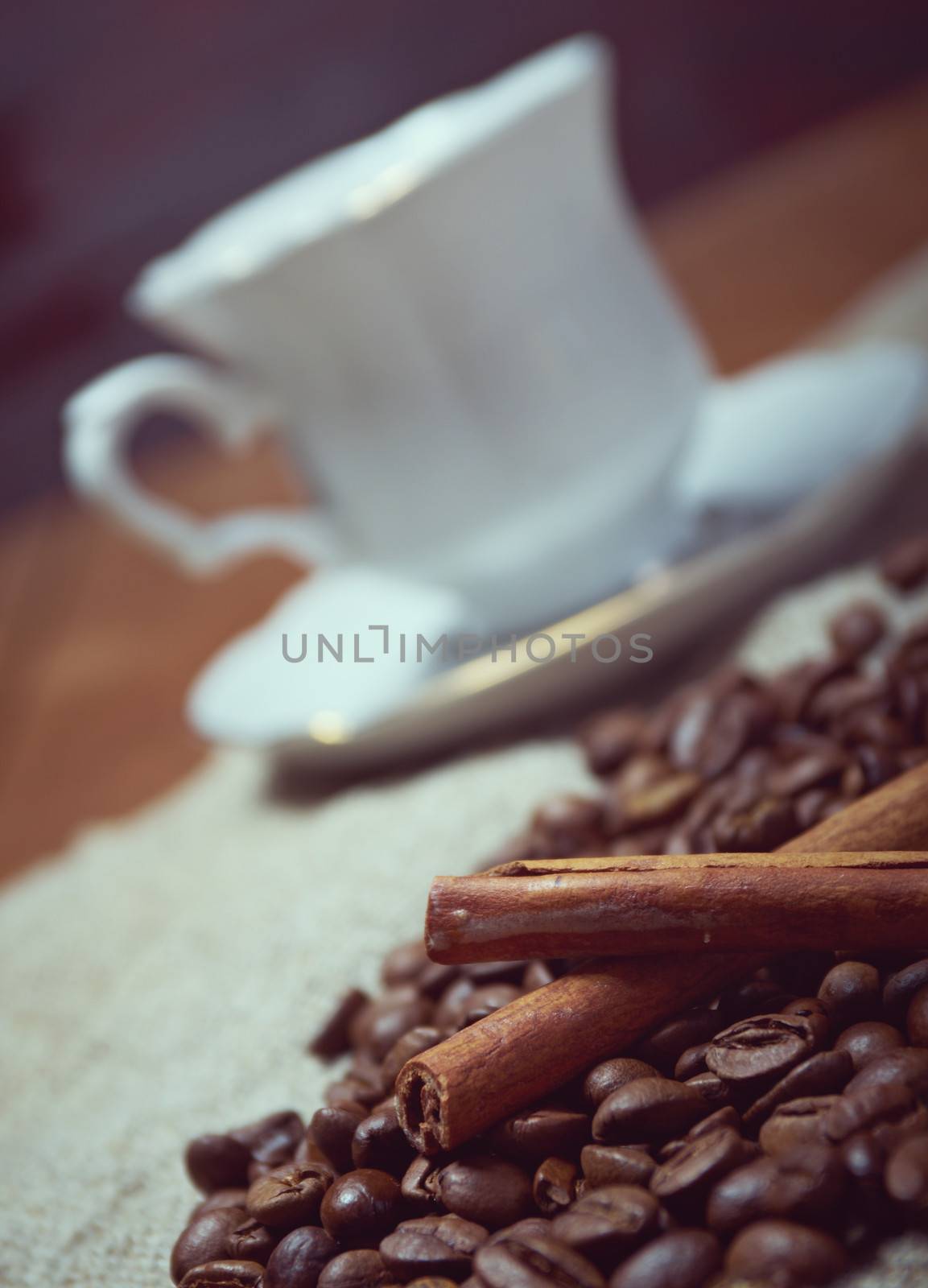 Coffee cup with cinnamon and coffee beans background