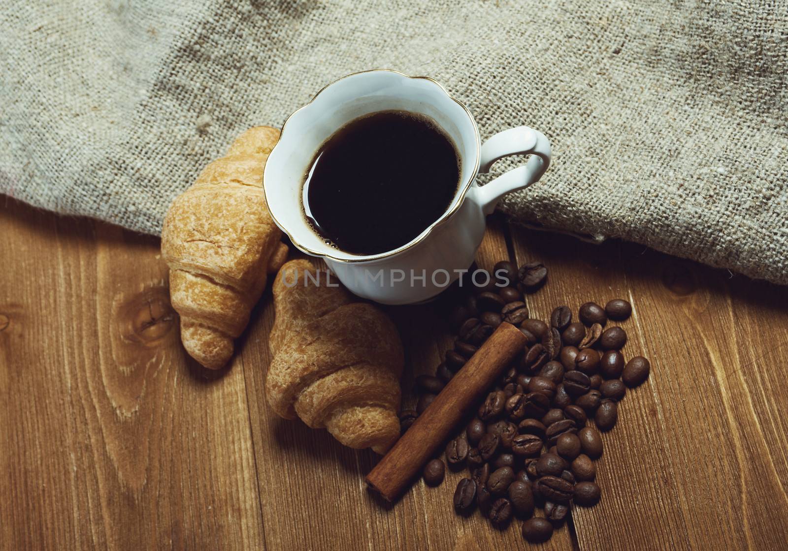 Coffee cup with cinnamon and coffee beans background