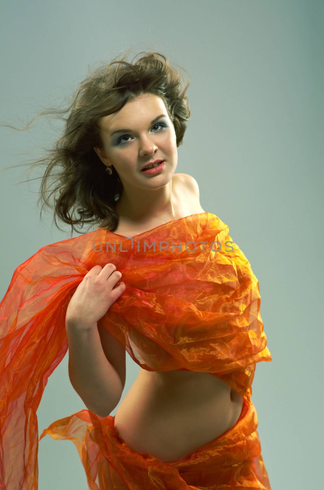 Beautiful woman in  waving fabric.Portrait of young dancing girl