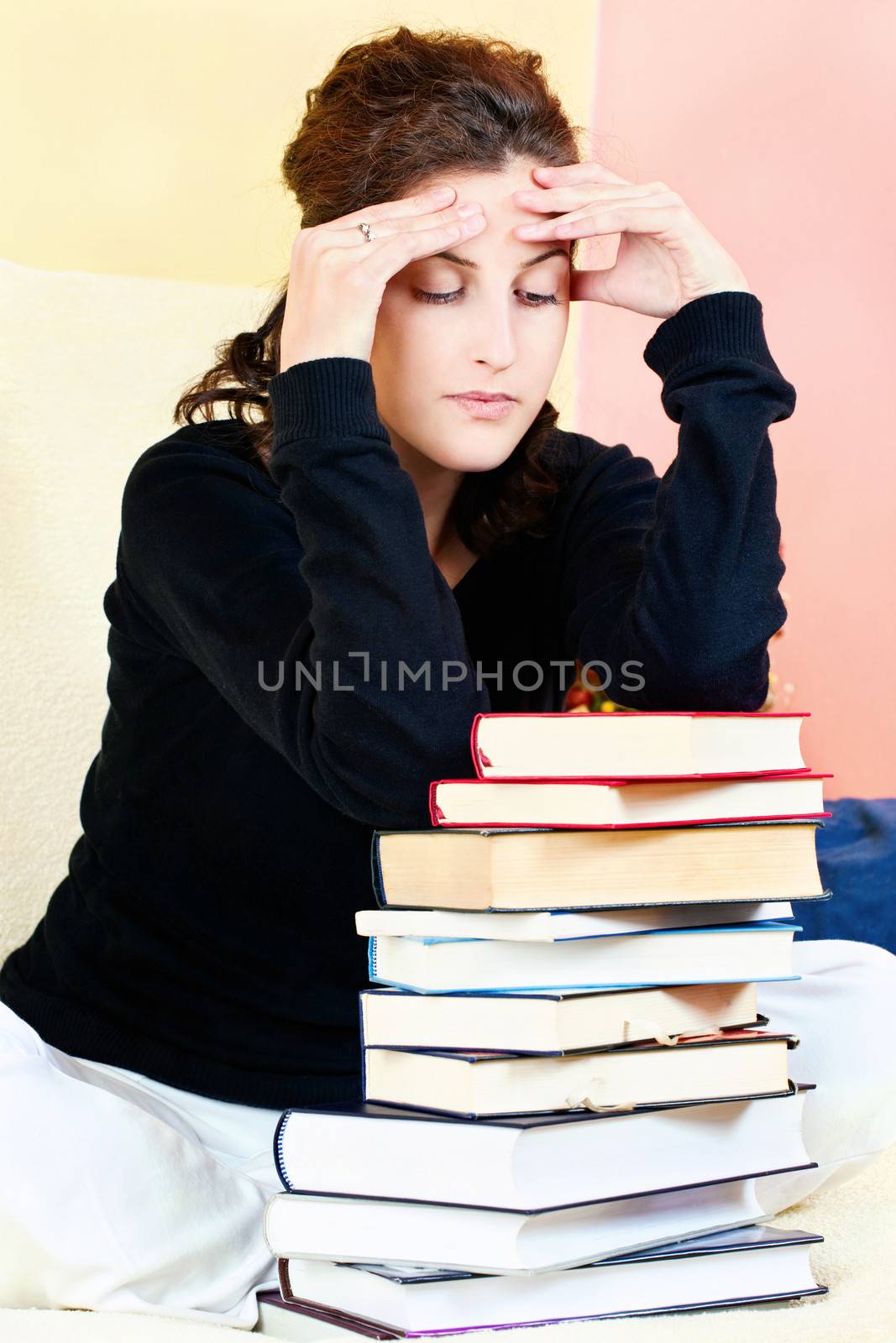 Worried female student and bunch of books at home