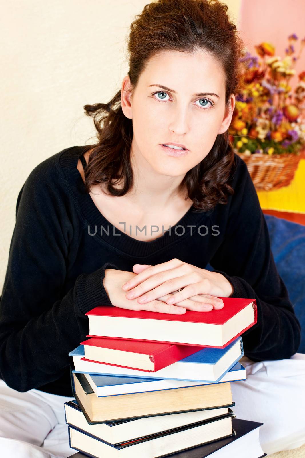 Female student and bunch of books at home