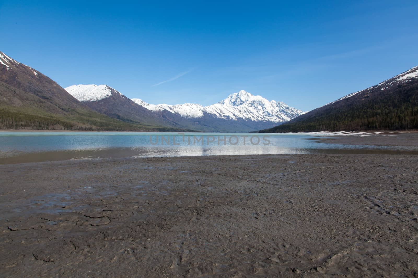 A large blue lake begins to melt on a hot spring day