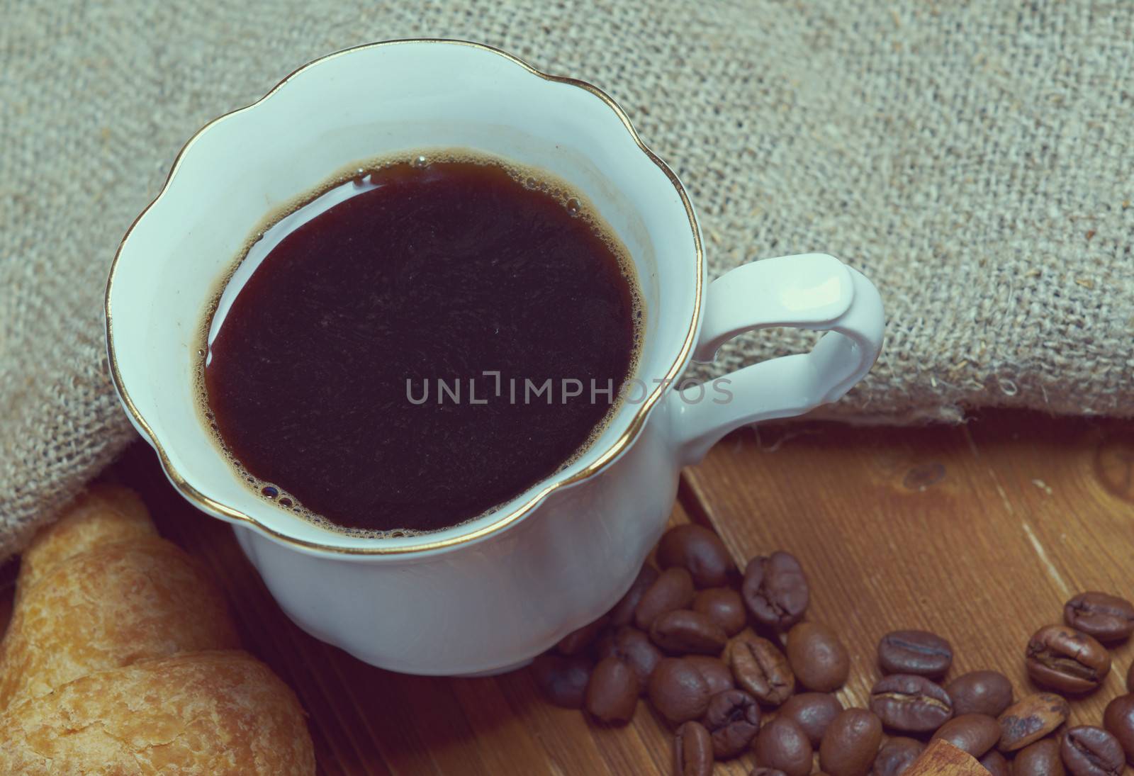 Coffee cup with cinnamon and coffee beans background