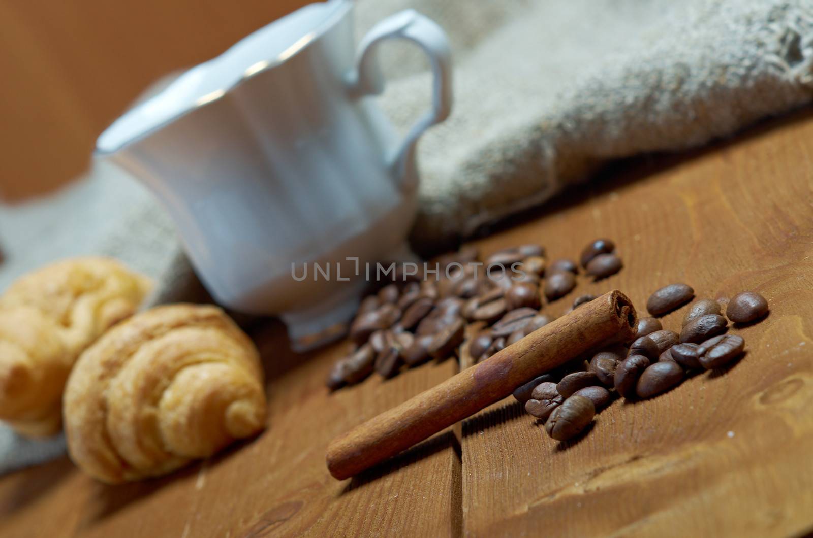 Coffee cup with cinnamon and coffee beans background