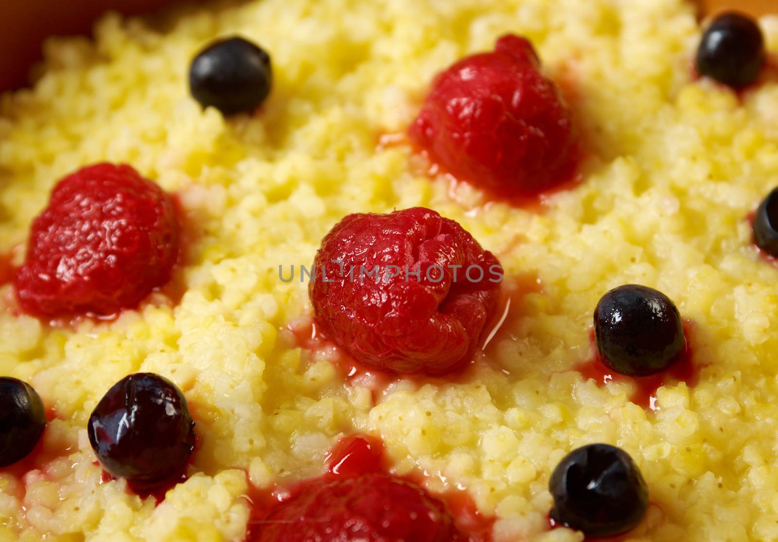 Millet porridge with berry in brown bowl on table