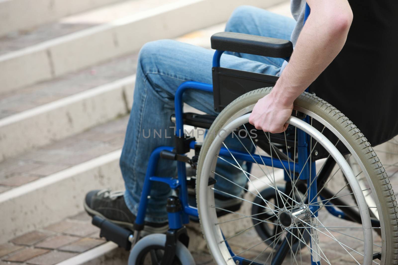 A young man in a wheelchair who can't get up the stairs