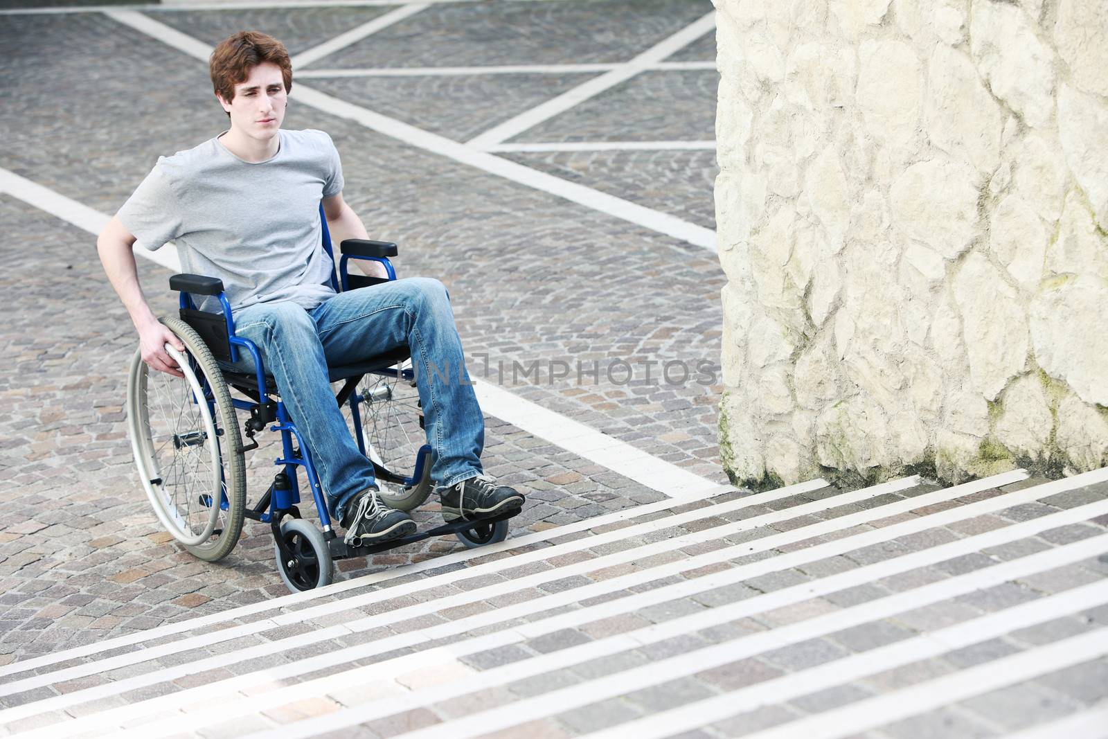 A young man in a wheelchair who can't get up the stairs