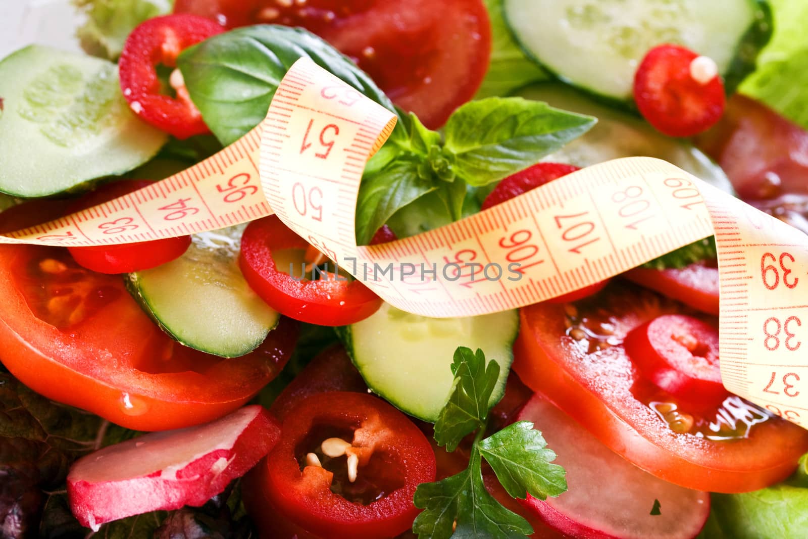 Vegetables and centimeter. Centimeter on the background of salad