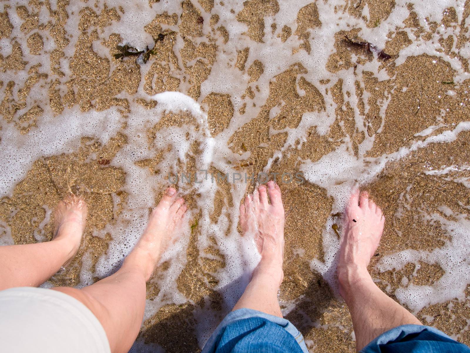 Feet in the sand and water by Talanis