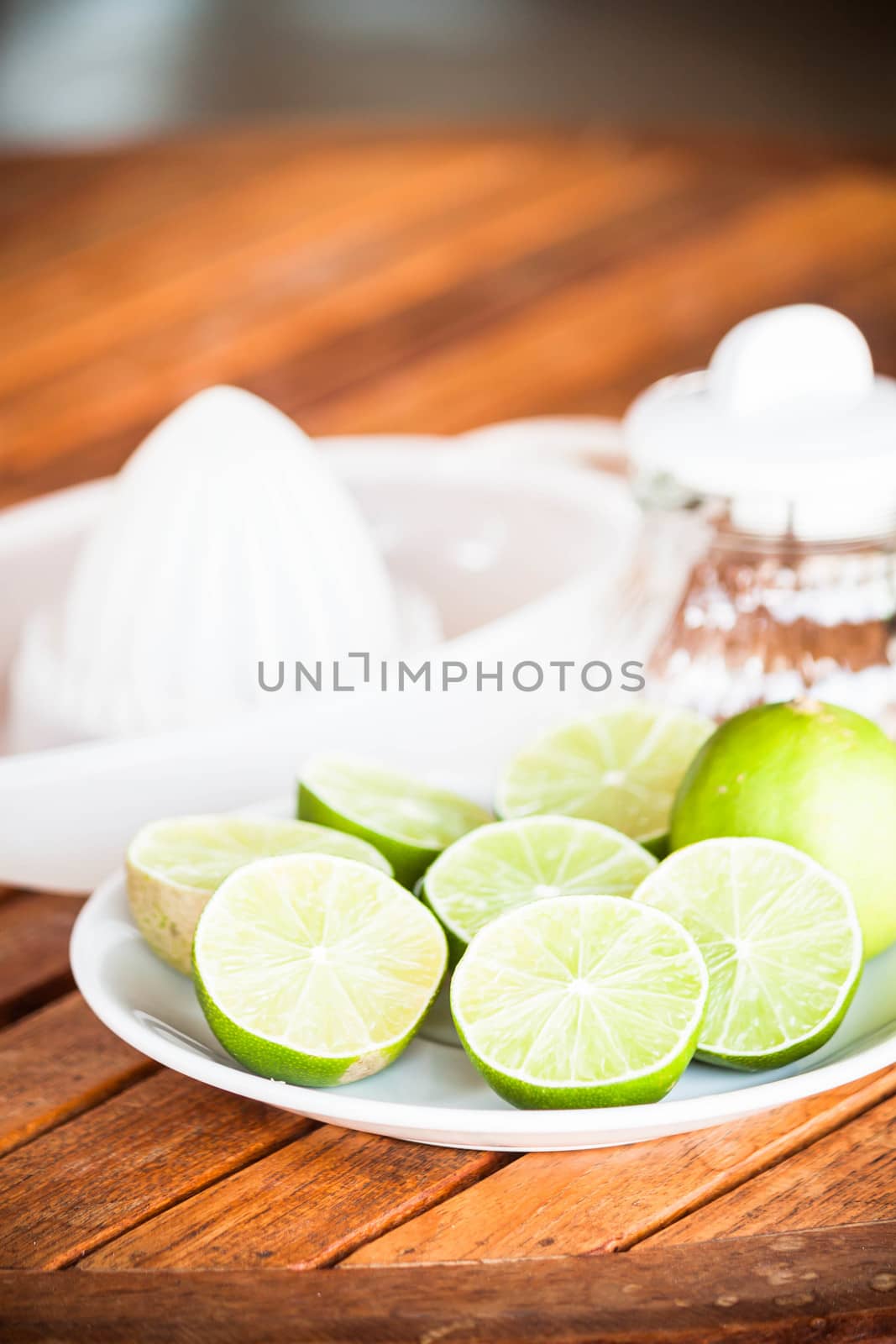 Fresh citrus lime wholes and slice with hand squash tool by punsayaporn