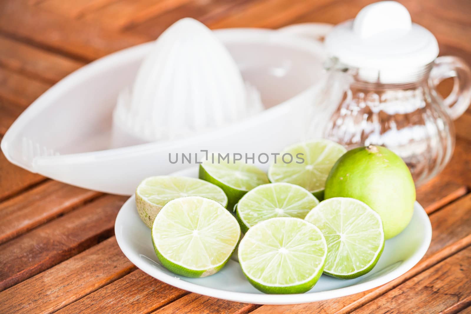 Fresh citrus lime with glass jar and hand squash tool by punsayaporn