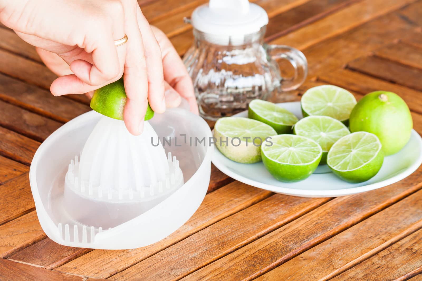 Hand squashing fresh lime on wood table