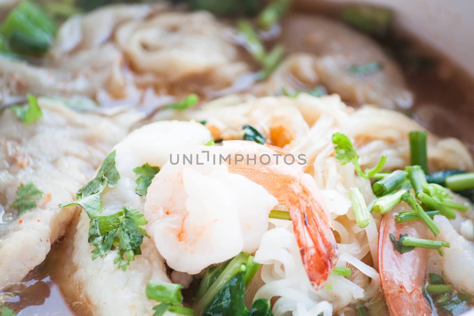 Close up shrimp topped on thai style spicy noodles soup