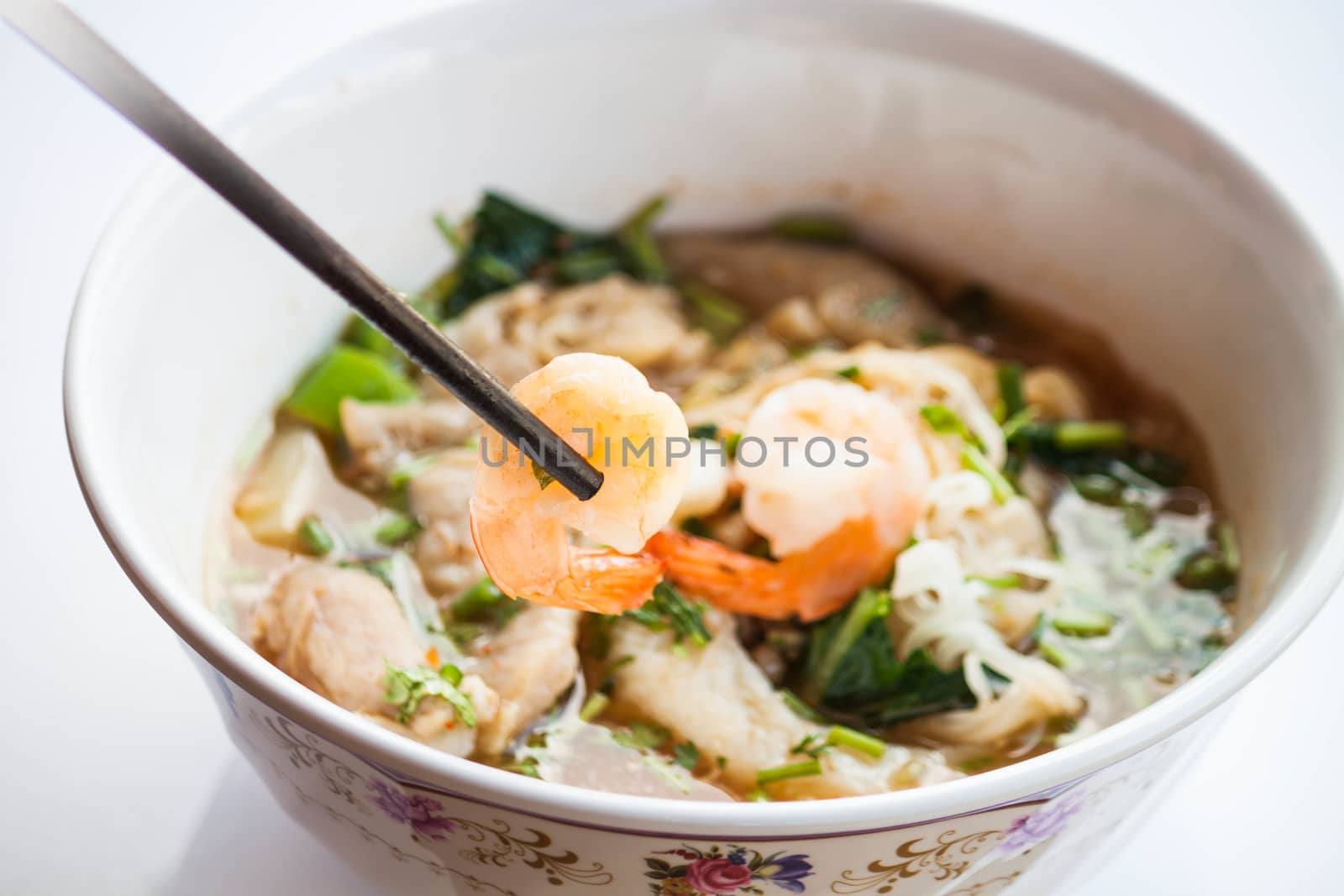 Hand hold shrimp with chopsticks of thai style spicy noodles sou by punsayaporn