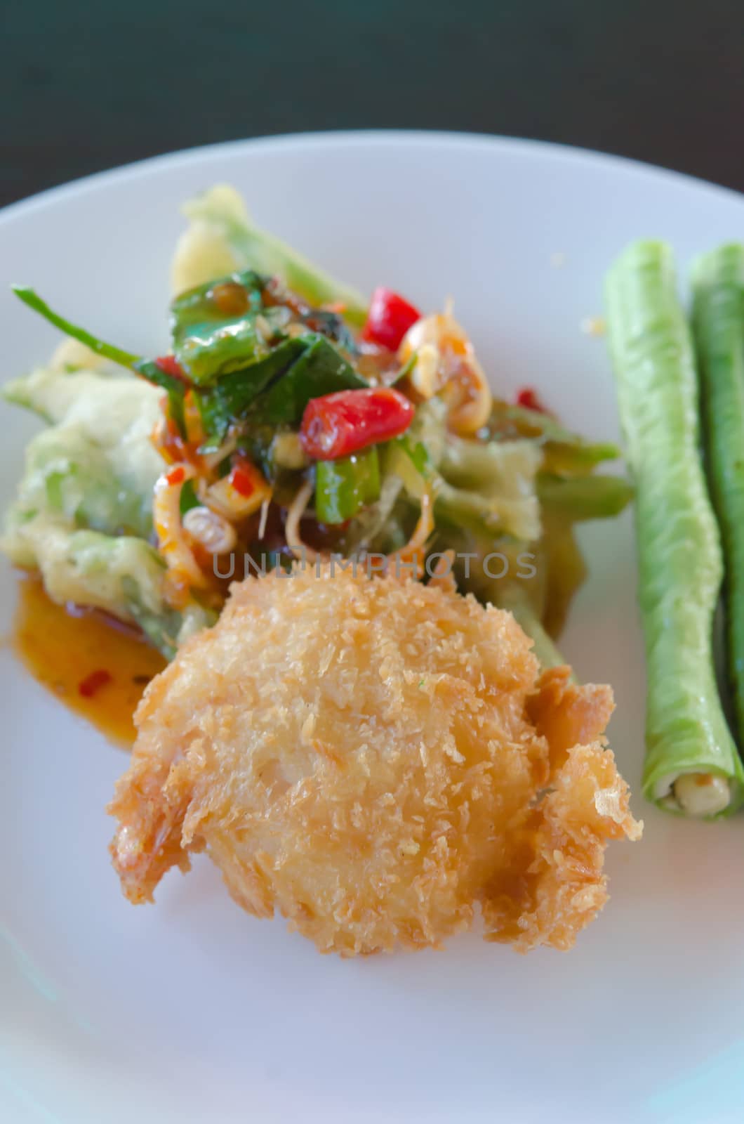close up crispy shrimp and crispy vegetable served with chili sauce and fresh vegetable on white plate