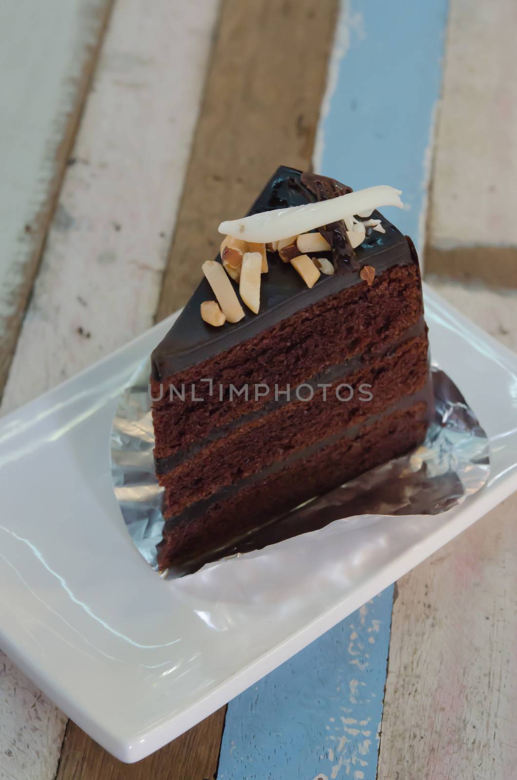 Dark chocolate cake  with nuts and coconut on white plate